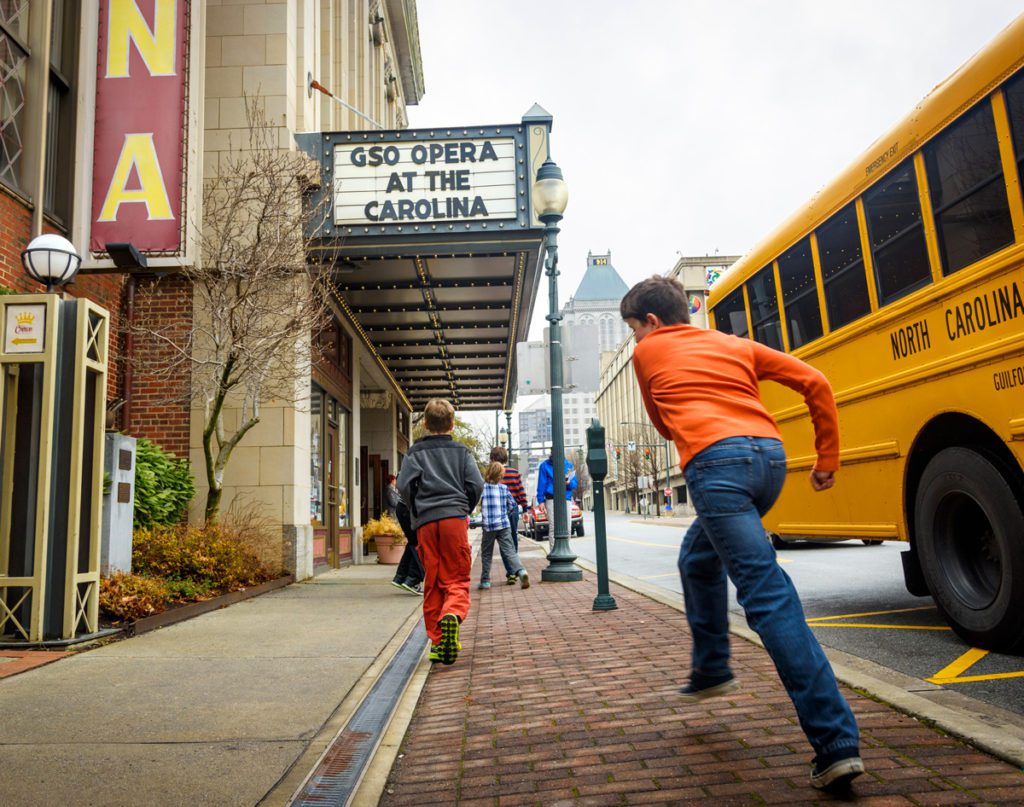 Children walking past the Carolina Theatre in downtown Greensboro, NC