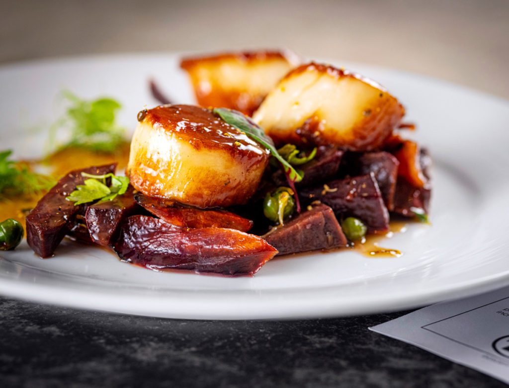 Seared scallops with roasted vegetables at a Greensboro restaurant