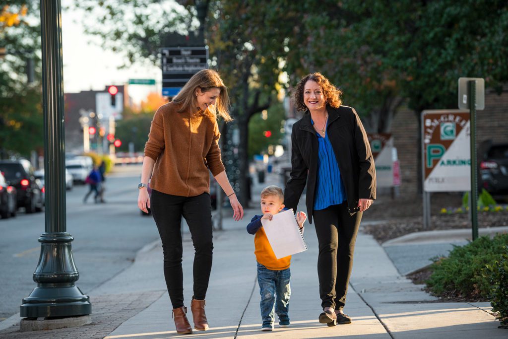 Melissa Greer walking with a family in downtown Greensboro, NC